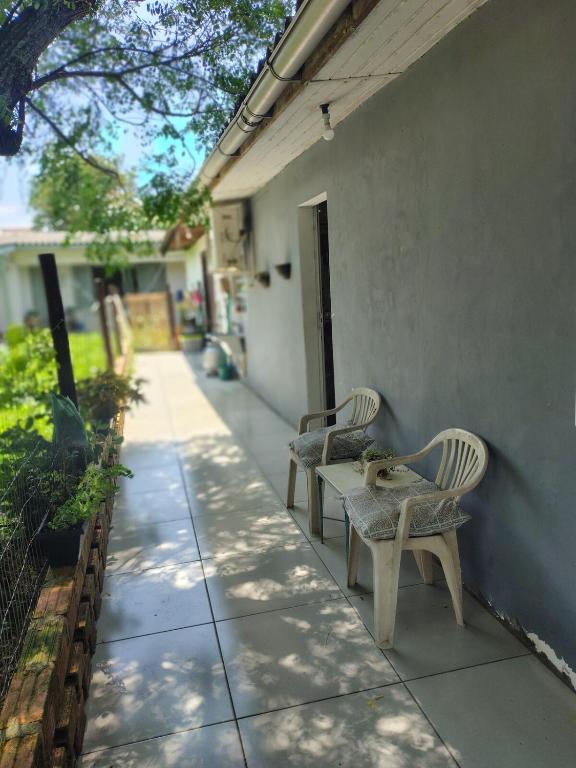 two chairs and a table on the side of a building at Apartamento sossegado e bairro tranquilo in Torres