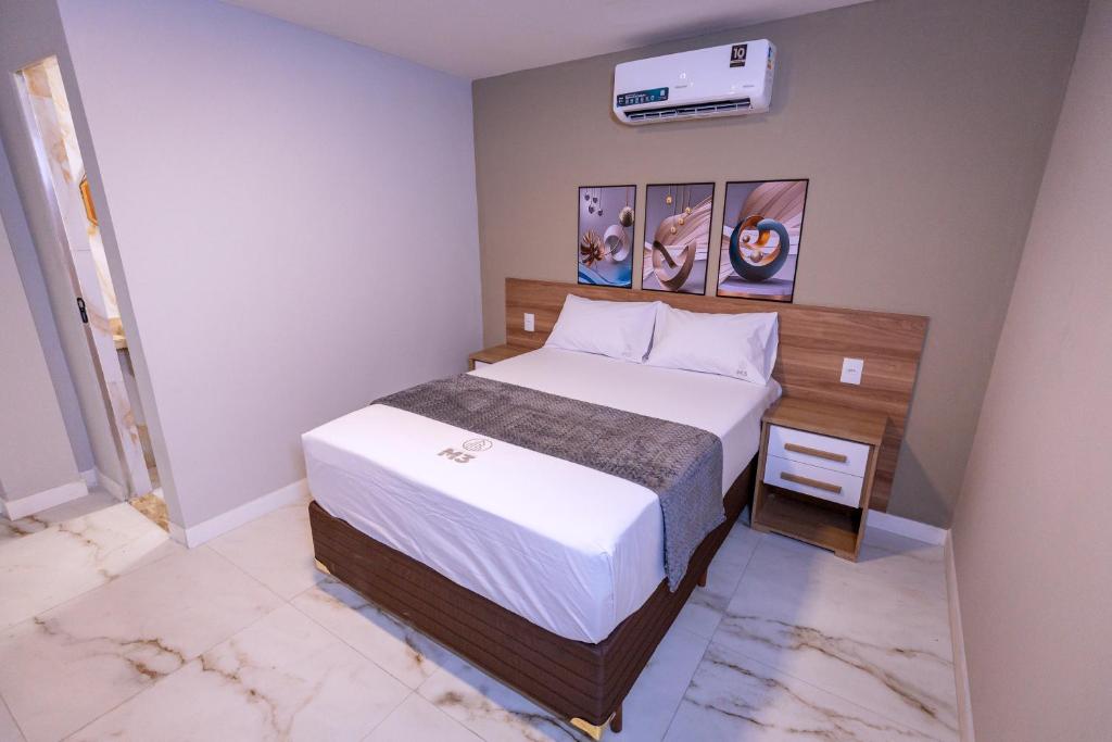 a small bedroom with a bed and a air conditioner at M3 Studio Hotel in Camaçari