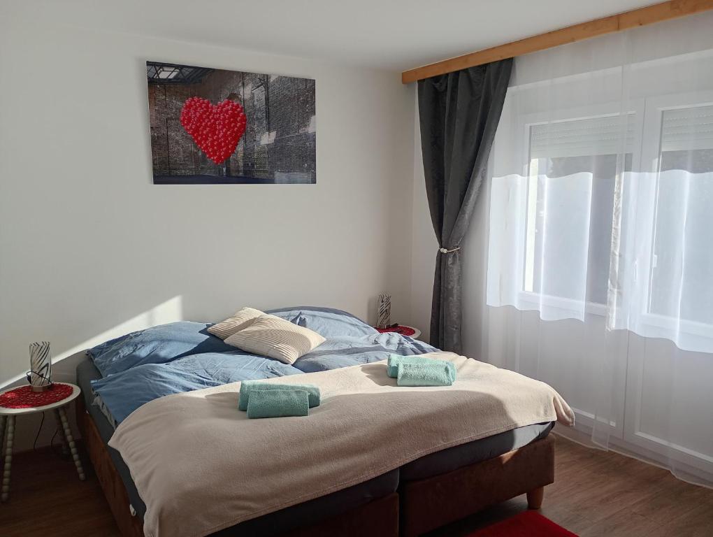 a bed in a bedroom with a heart picture on the wall at SeeSternchen in Faak am See