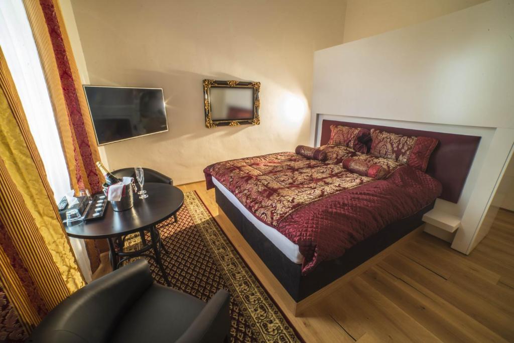 - une chambre avec un lit, une table et un miroir dans l'établissement Hotel Panství Dlouhá Lhota, à Dlouhá Lhota