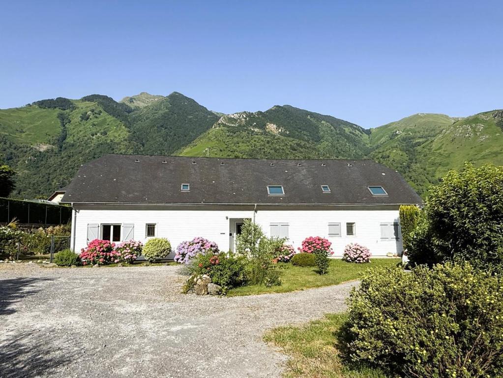 una casa bianca con le montagne sullo sfondo di Lo Saunei a Laruns