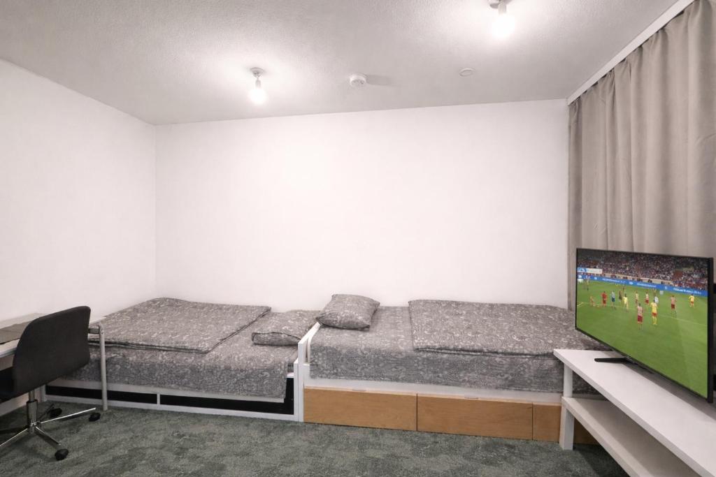 a room with two beds and a tv and a desk at City Heaven in Turku