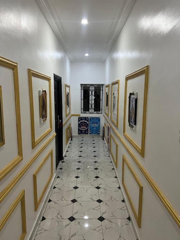 a hallway with paintings on the walls and a tile floor at Otijoe Premier Hotel in Port Harcourt