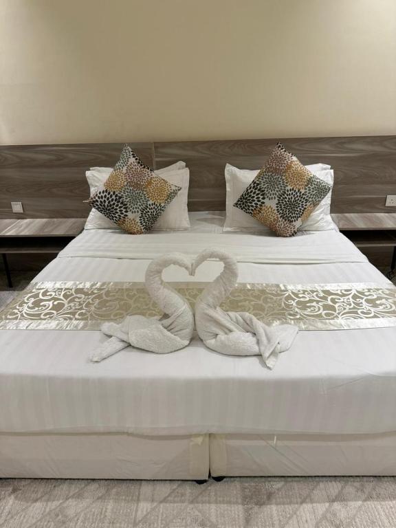 two swans making a heart shape on a bed at Marina Jada hotel in Jeddah
