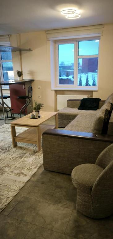 a living room with a couch and a table at Masčio apartamentai in Telšiai