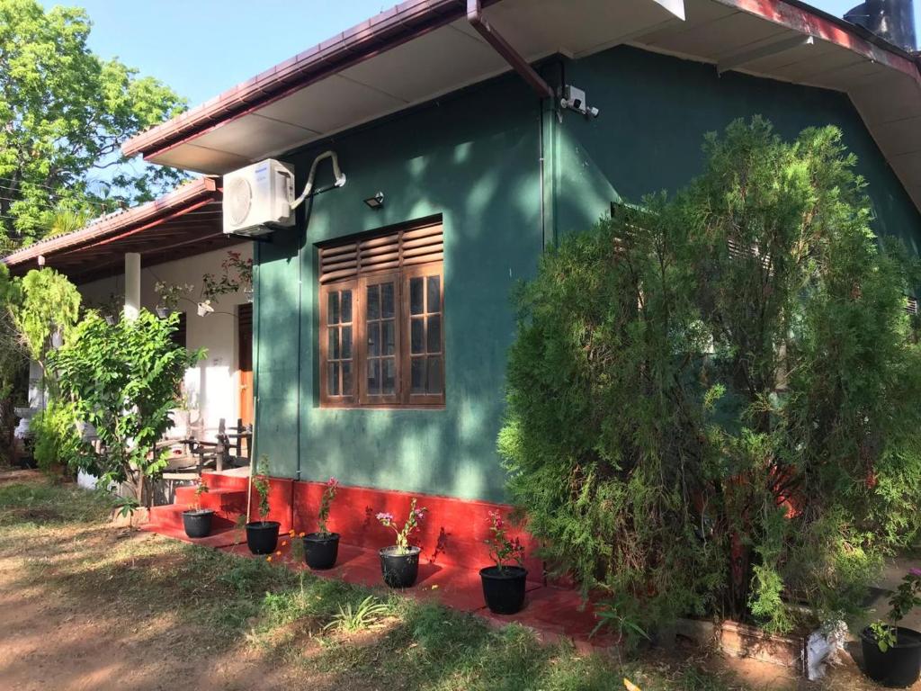 a green house with potted plants in front of it at Wild Wild Holiday in Kataragama