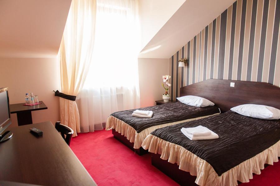a hotel room with two beds with towels on them at Hotel Podzamcze in Góra Kalwaria