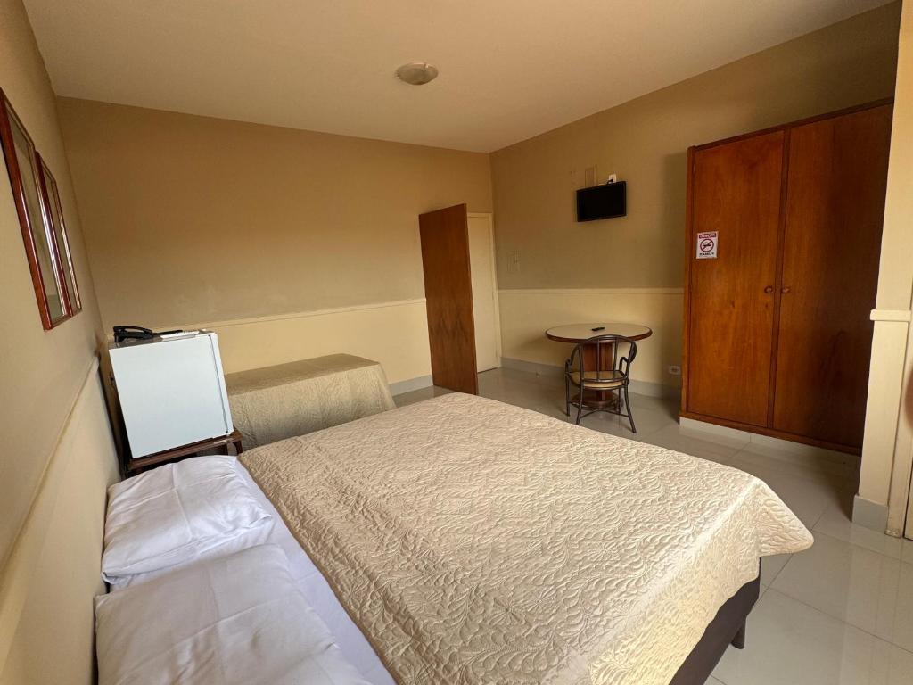 a hotel room with a bed and a table at Hotel Executive Uberaba in Uberaba