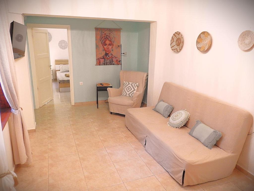 a living room with a couch and a chair at Eva's Eden in Vourvourou