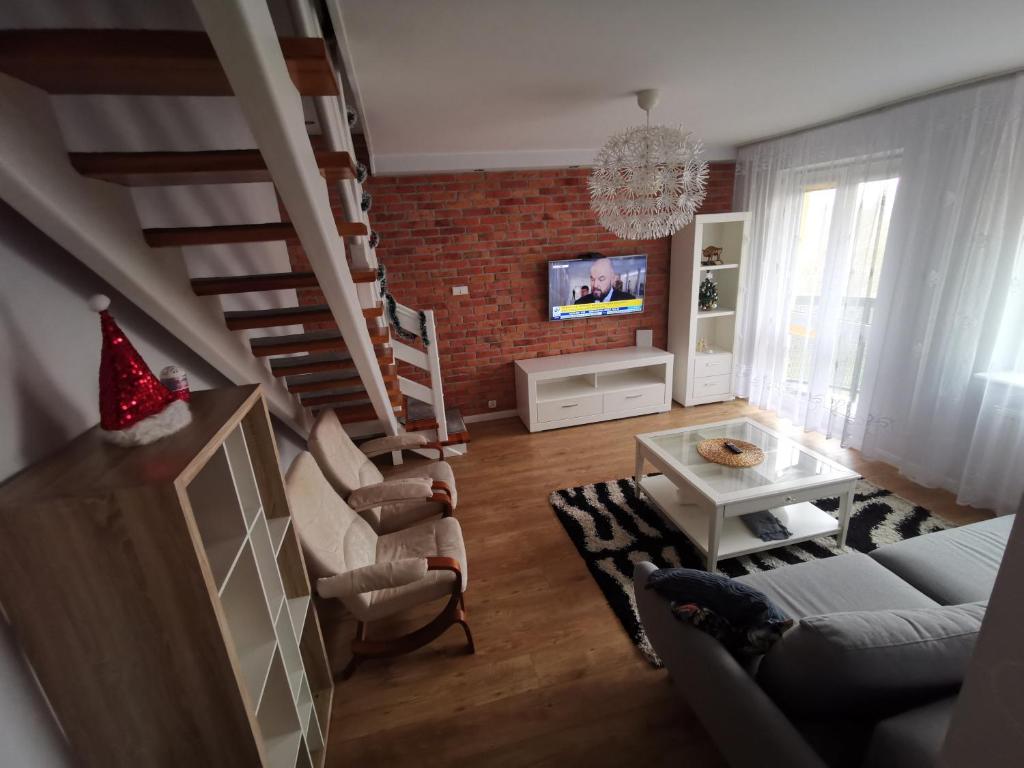 a living room with a couch and a staircase at Dwa poziomy Wrocławska in Białystok