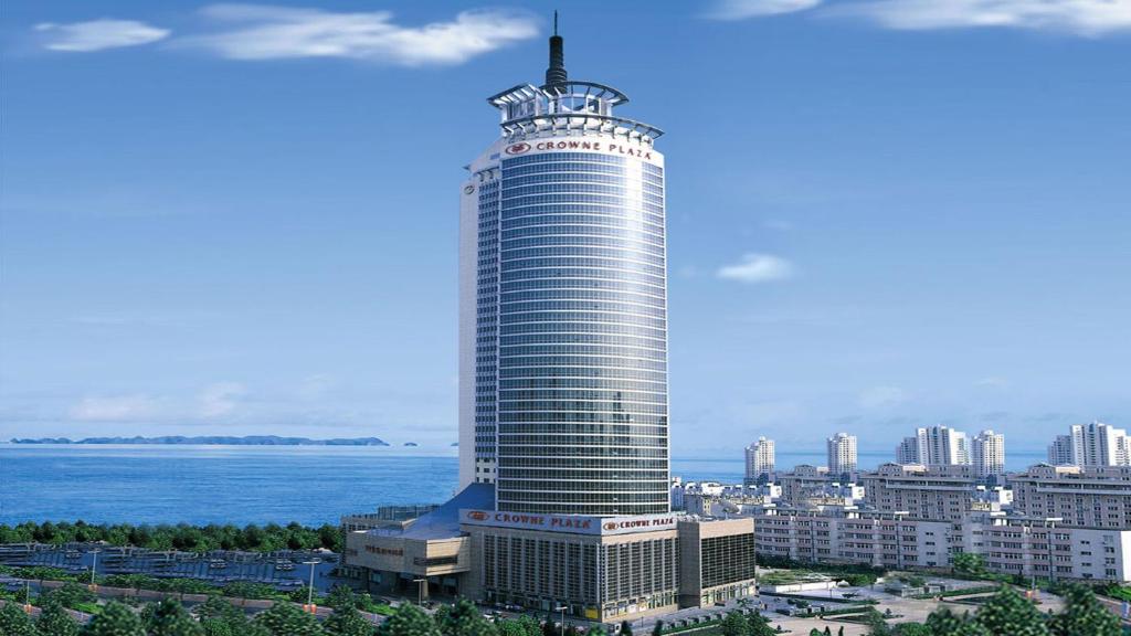 a tall building with a pole on top of it at Crowne Plaza Qingdao by IHG in Qingdao