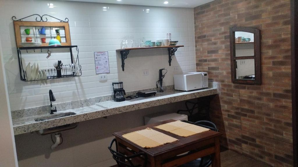 a kitchen with a counter with a sink and a microwave at Central Apartment 2 in Ouro Preto