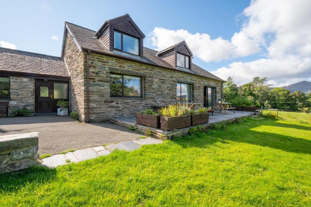 a stone house with a garden in front of it at 4 Bed in Ffestiniog oc-bow172 in Ffestiniog