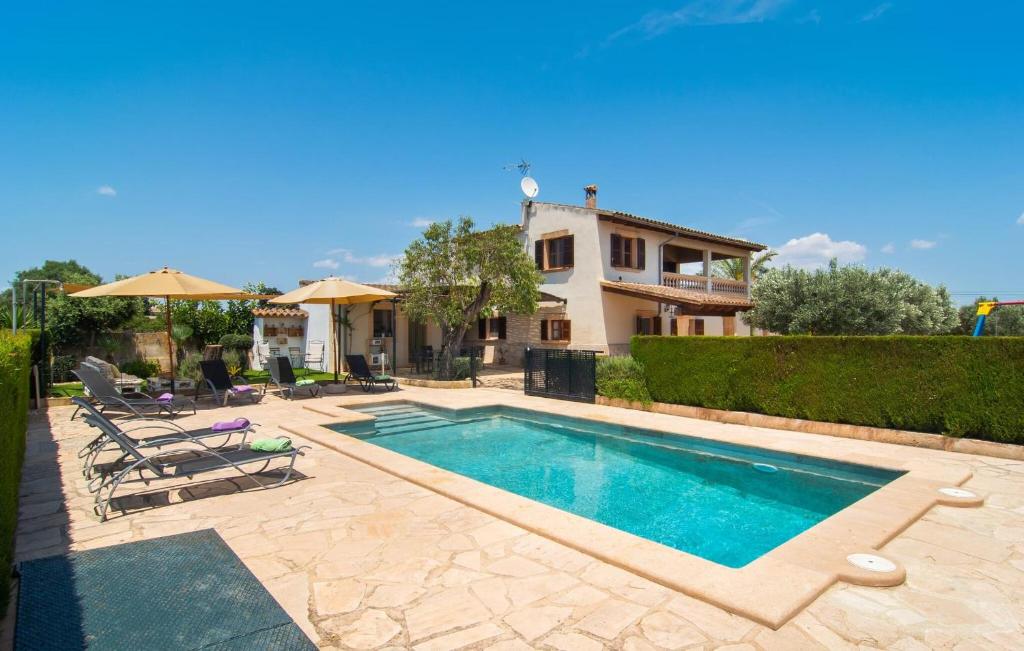 a swimming pool in front of a house at Es Cipres in Porreres