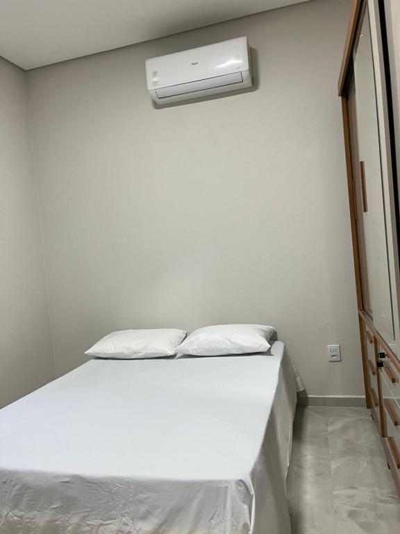 a bedroom with a bed with a air conditioner on the wall at CasAnita in Cavalcante