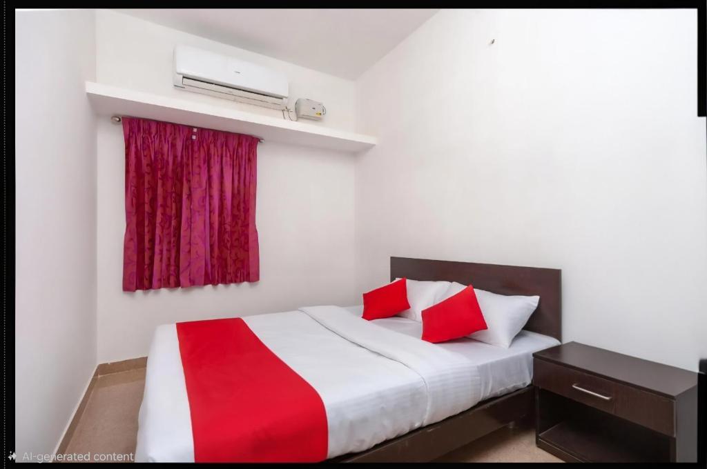 a bedroom with a white and red bed with a window at Varun Residency New in Coimbatore