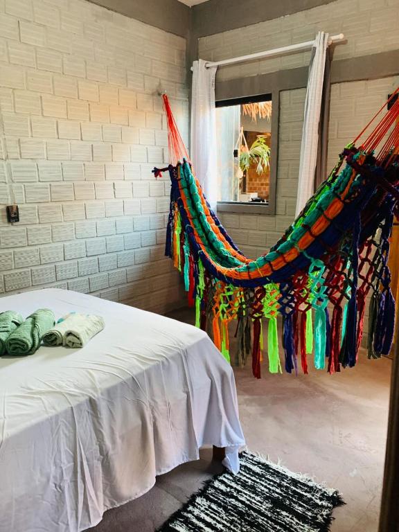 a bedroom with a bed with a curtain and a window at Pousada Portal D'amaro in Santo Amaro