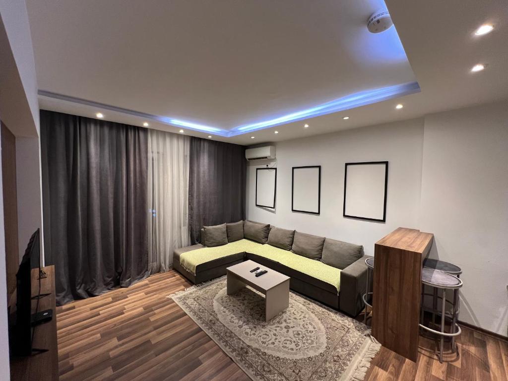 a living room with a couch and a table at Central View Prishtina in Prishtinë