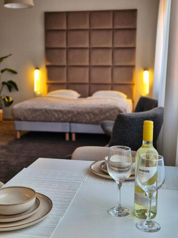 a table with a bottle of wine and two glasses at Apartament Strumyk in Czarnków