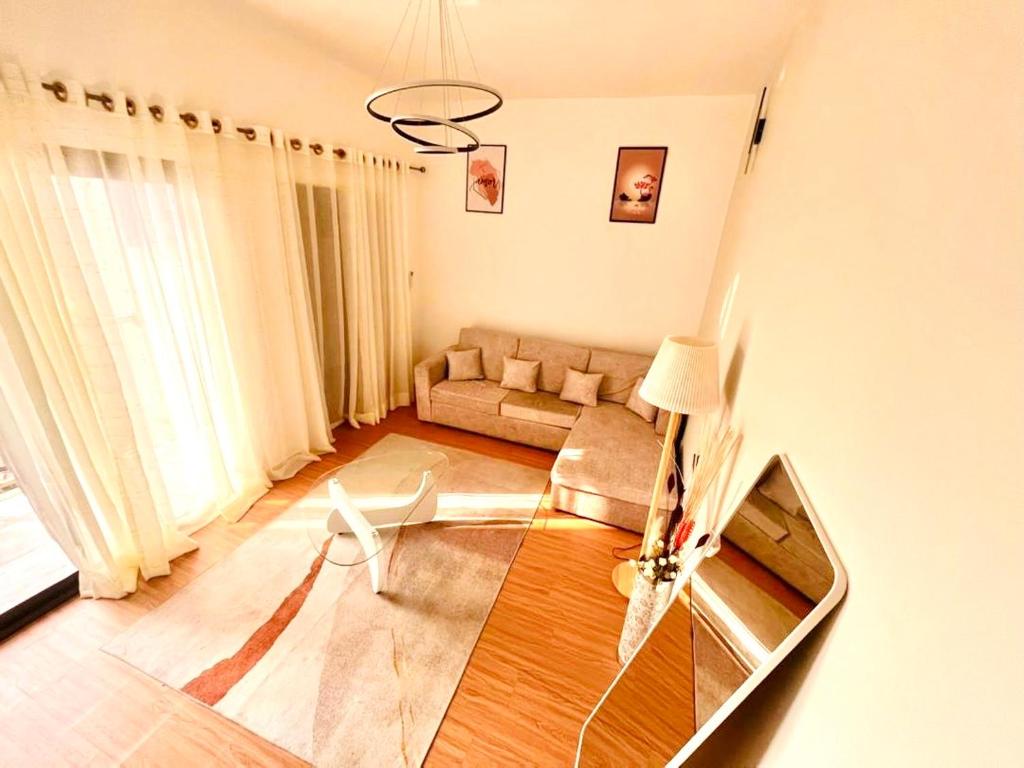 un soggiorno con un divano e un tavolo di vetro di Western Suites a Douala