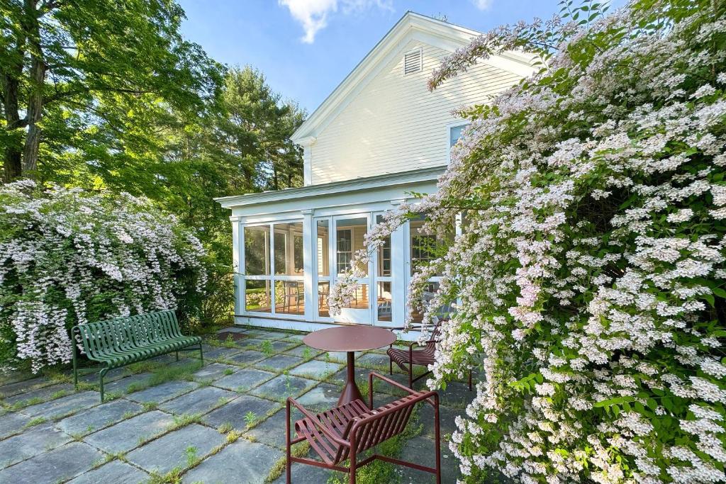 eine Terrasse mit Tisch, Stühlen und Blumen in der Unterkunft Close to Copake Lake! 4-Season Escape w/ Sauna in Copake