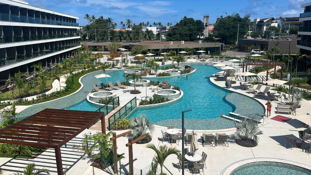 a resort with a large swimming pool and a resort at Flat Lindo em Muro Alto Resort Beach Class Verano Porto de Galinhas in Porto De Galinhas