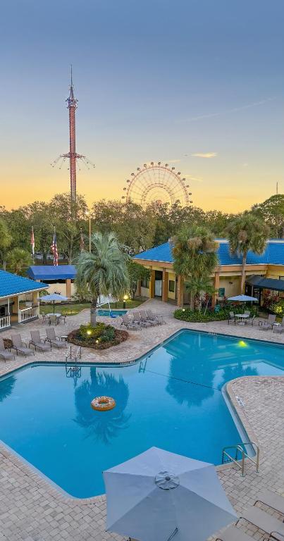 a large blue swimming pool in front of a resort at Hotel Monreale Express & Studios IDrive District in Orlando