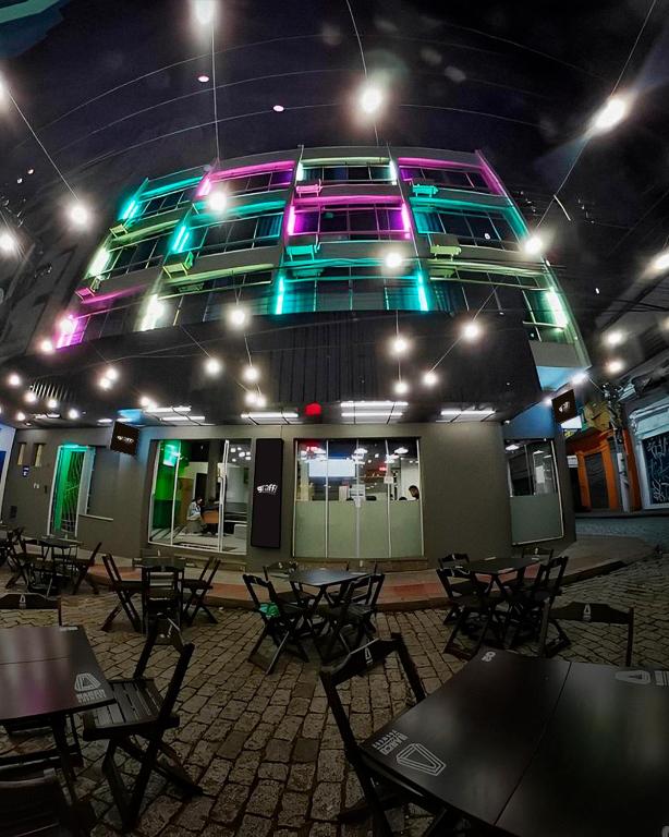 a room with tables and chairs and a building with lights at Graffi City House in Florianópolis