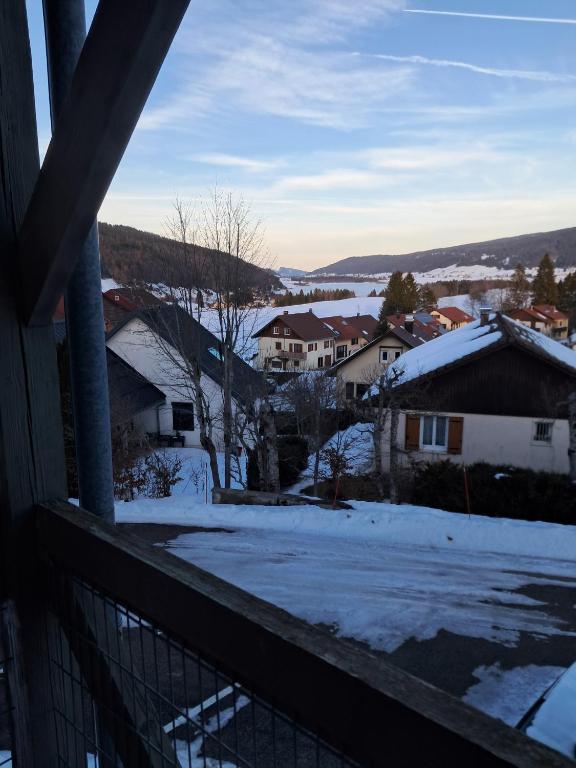 a view of a town in the snow from a balcony at 265 rue du clos capperony in Les Rousses