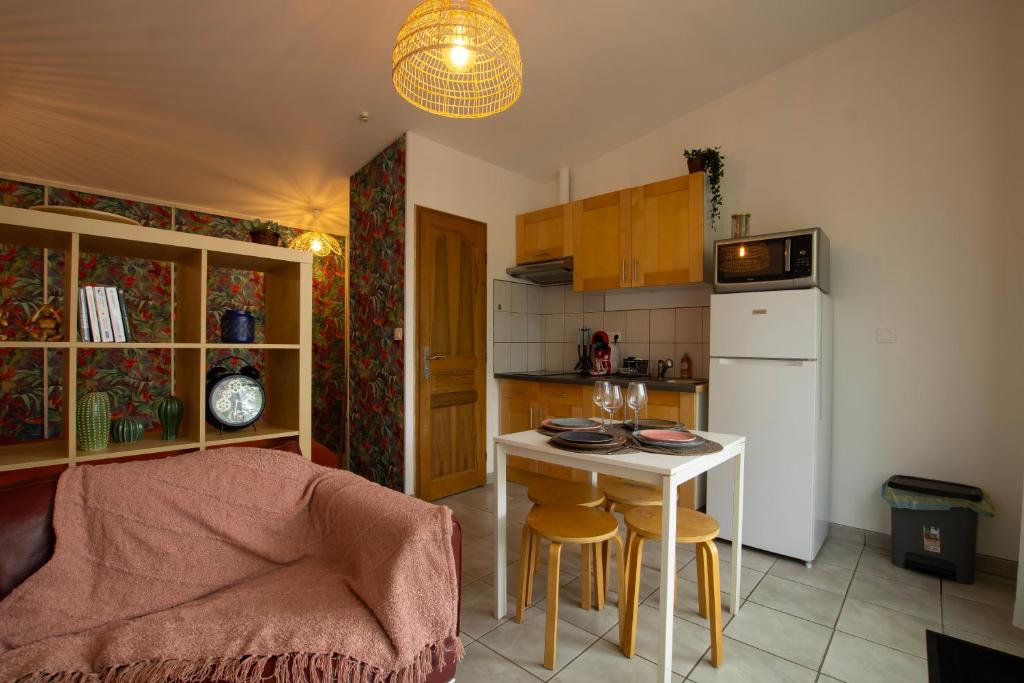 a kitchen with a table and a small kitchen with a refrigerator at La cabanne aux bambous in Villenave-dʼOrnon