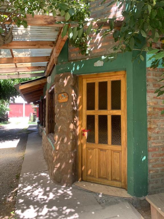 a house with a wooden door on the side of it at Torres del Piltri in El Bolsón