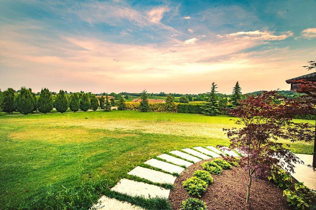 a grassy field with a stone path in the middle at Agriturismo Olistico Atman in Monzambano