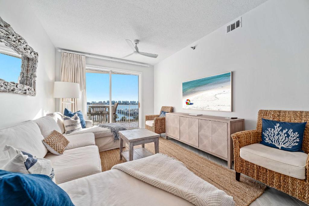a living room with a couch and a tv at Harbor Cove 404 in Orange Beach