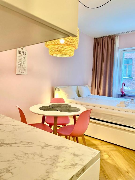 a room with a bed and a table and chairs at Studio Flamingo in Helsinki