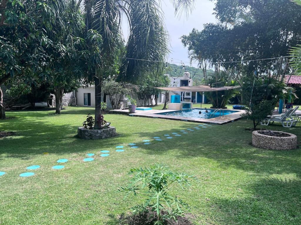 a yard with a house and a swimming pool at Exclusive paradise surrounded by nature in Alpuyeca
