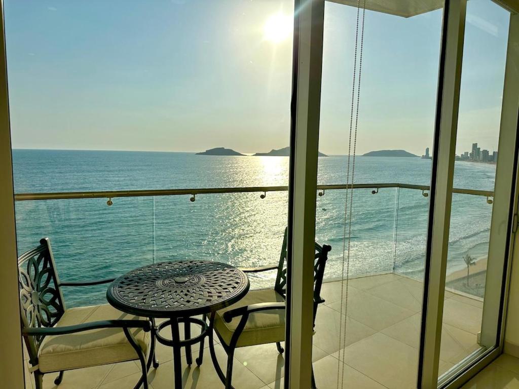 a table and chairs on a balcony with the ocean at Sunset view luxury in Cedro