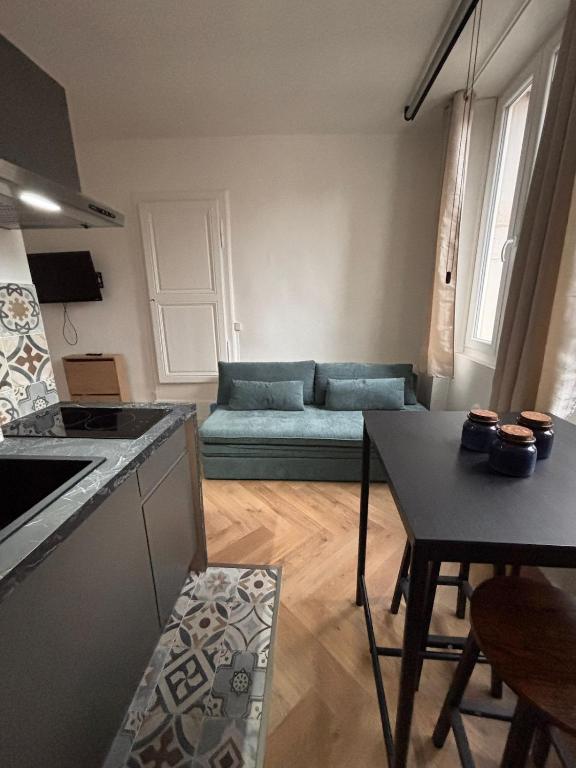 a kitchen and a living room with a couch at Le Cocon Dijonnais - Cours Cambronne in Dijon