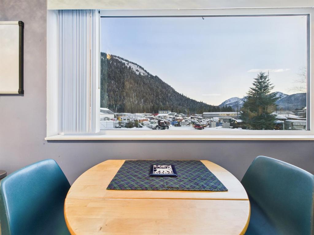 a table and chairs in a room with a large window at Large Juneau Loft w Full Kitchen, WD & Workspace in Juneau