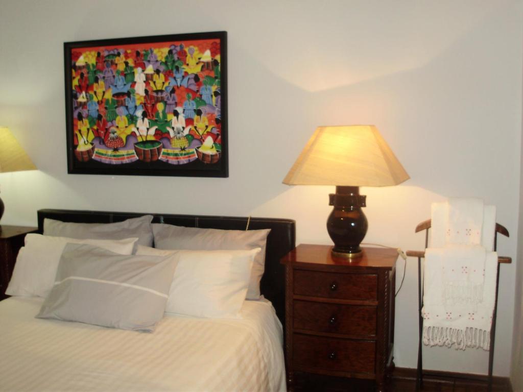 コインブラにあるMiguel Torga Roomのベッドルーム1室(ランプと絵画付)