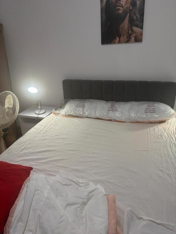 a white bed with a person laying on it at Kay Borsa in Alba Iulia