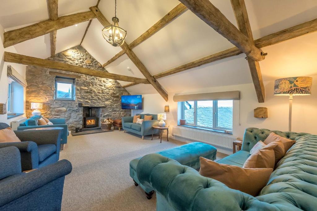 a living room with blue furniture and a stone wall at Melin-Bennar in Dyffryn