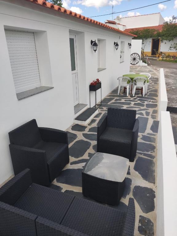 a patio with chairs and tables and a building at Casa da Roda in Arronches
