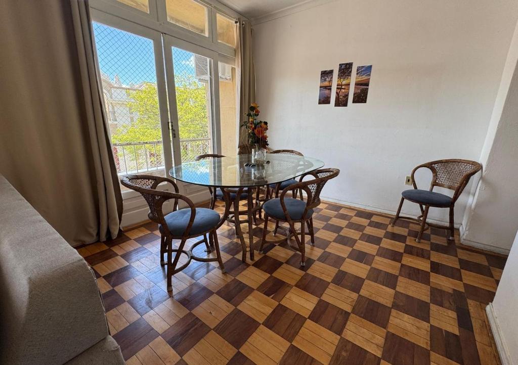 a dining room with a glass table and chairs at Apto Pet Friendly com Ar condicionado no Centro in Bagé