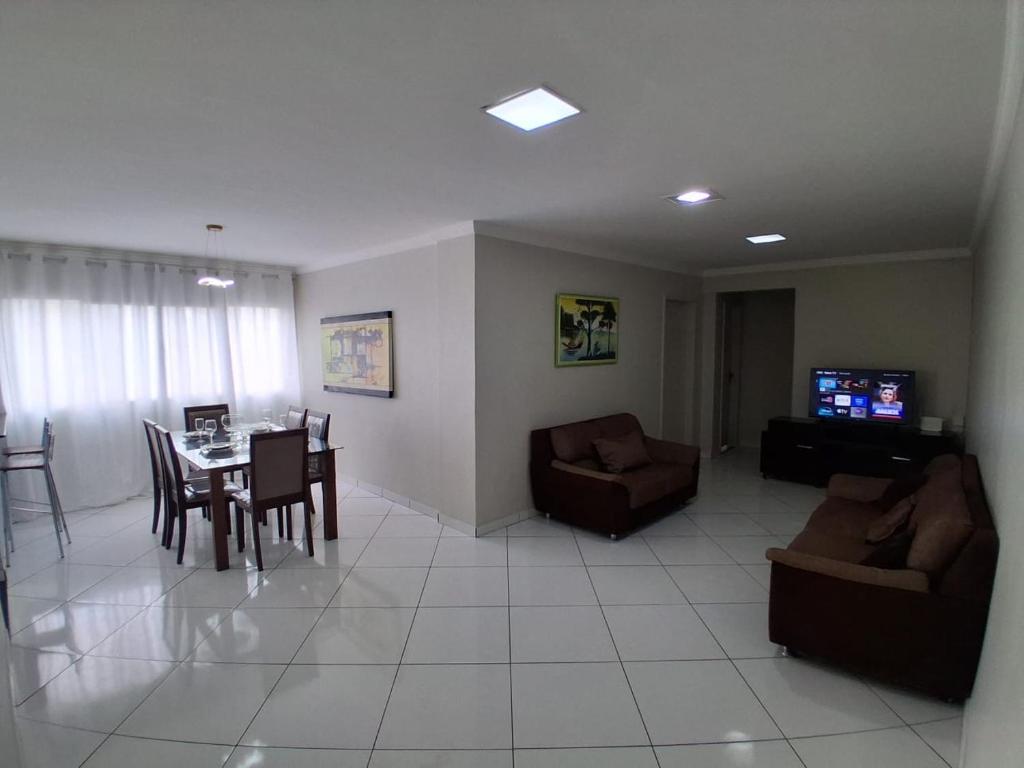 a living room with a couch and a table and chairs at Edifício Gentil Gomes in Montes Claros