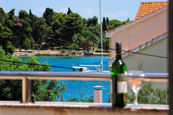 a bottle of wine on a balcony with a view of a river at Apartmani Antea in Preko