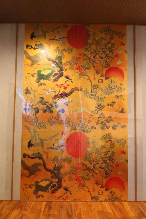 a wall with a painting of a tree at 京都 大阪アクセス良好の和モダン民泊 静かで快適な宿泊施設です 京阪本線楠葉駅から徒歩圏内 急行特急停車駅で京都へ約30分 大阪へ約40分とアクセス良好です in Hirakata