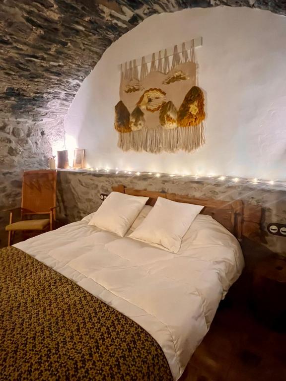 a bedroom with a bed with lights on the wall at Casa de piedra Siglo XVIII in Badaín