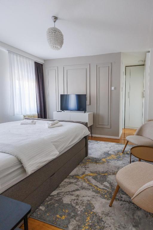 a bedroom with a large bed and a tv at Apartman Helena - Self check in in Osijek
