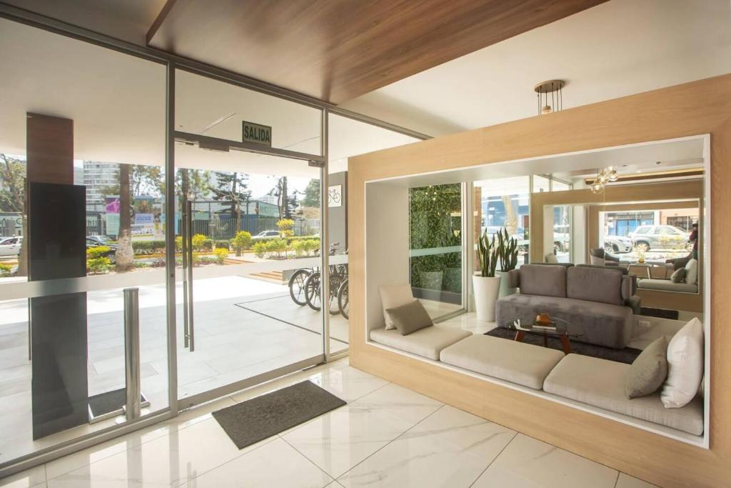 a living room with a couch and some windows at Barranco Modern Apartments with Rooftop Pool by Geko in Lima