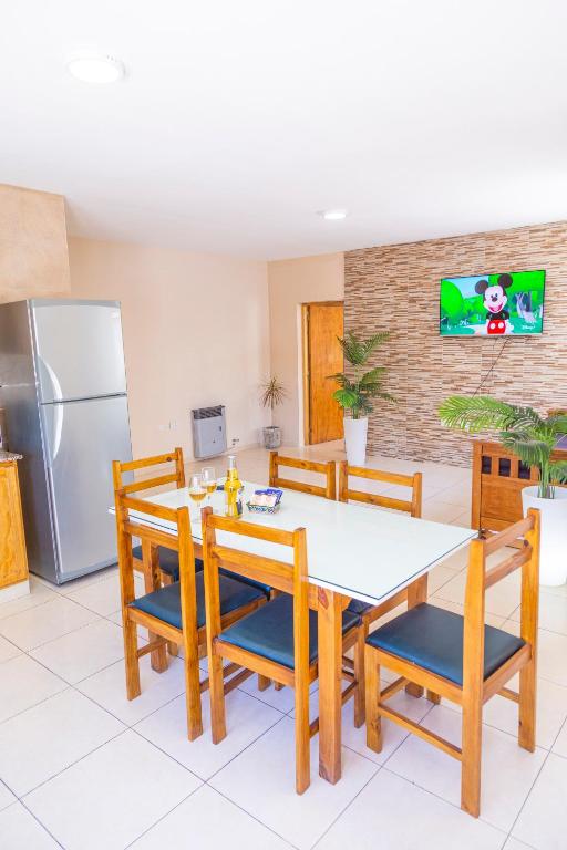 a kitchen with a table and chairs and a refrigerator at Departamentos Valle de los Andes in San Rafael